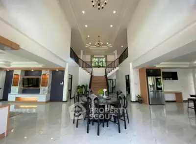 Luxurious open-plan living room with elegant staircase and modern furnishings