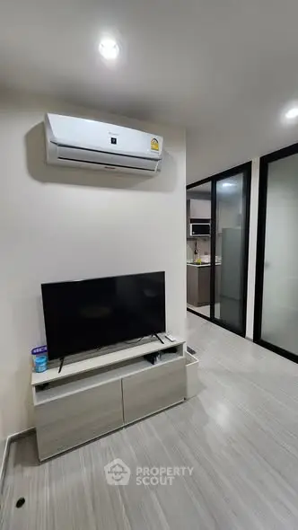 Modern living room with air conditioning and sleek TV setup in a stylish apartment.