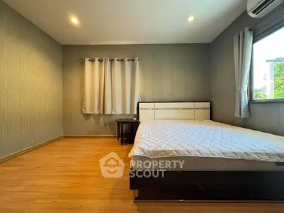 Spacious bedroom with modern decor and large window for natural light.