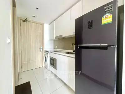 Modern kitchen with sleek appliances and washing machine in a compact layout