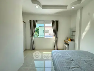 Bright and airy bedroom with modern design and large window offering natural light.