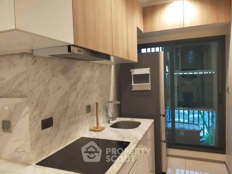 Modern kitchen with marble countertops and sleek appliances in a stylish apartment.