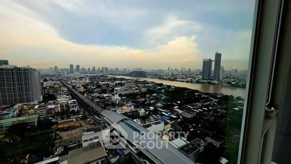 Stunning cityscape view from high-rise building window overlooking river and skyline.