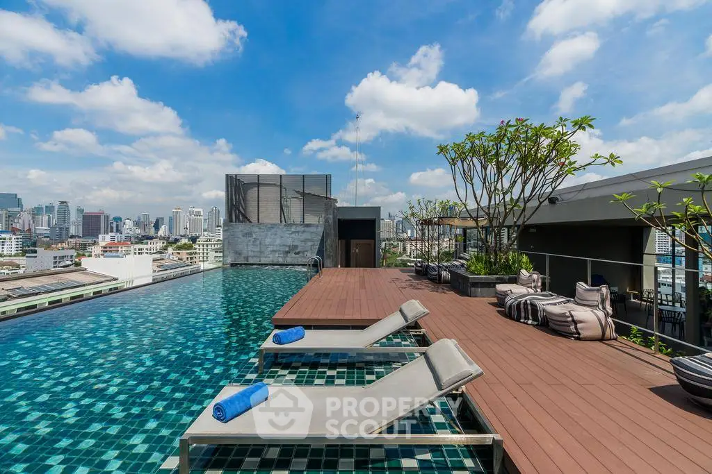 Luxurious rooftop pool with stunning city skyline views and modern lounge chairs.
