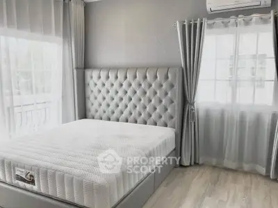 Luxurious bedroom with tufted headboard and large windows for natural light