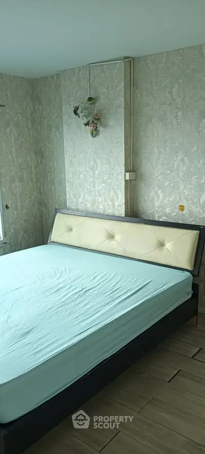 Spacious bedroom with elegant wallpaper and modern bed frame, perfect for a cozy retreat.
