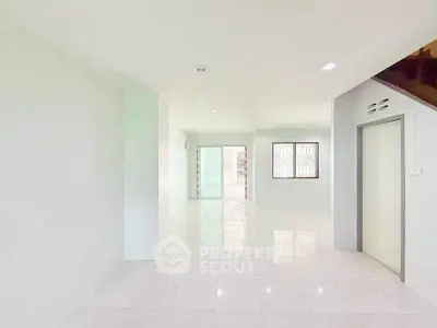 Spacious open-plan living area with bright natural light and modern tiled flooring.