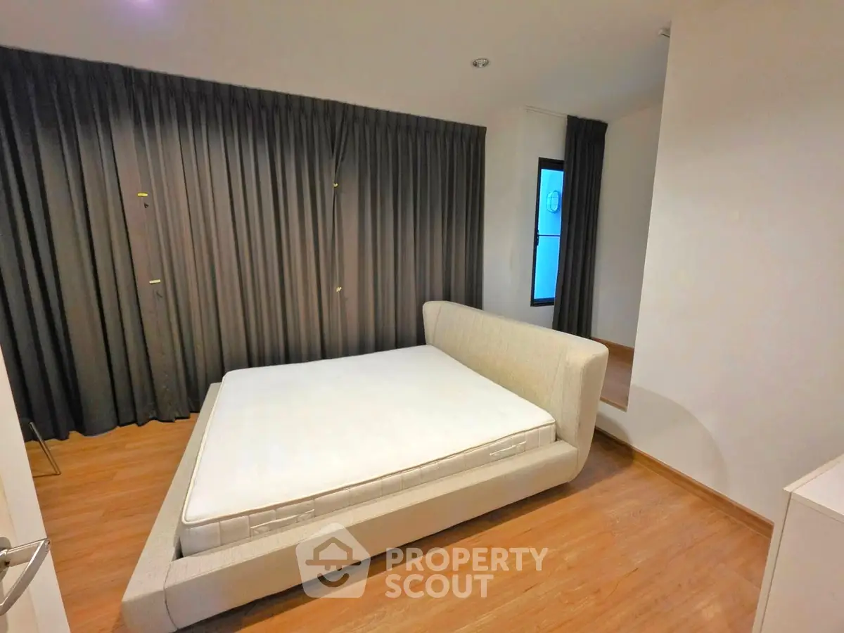 Spacious bedroom with modern design and large windows for natural light.