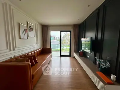 Modern living room with stylish decor and large window overlooking greenery.