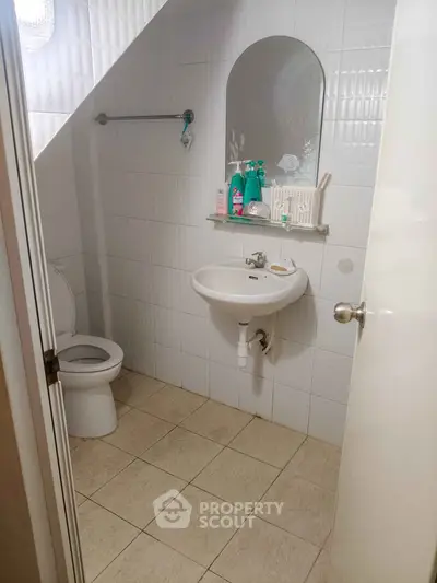 Cozy bathroom with modern fixtures and under-sink storage in a compact space.