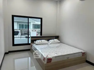 Modern bedroom with large window and stylish bed frame in a bright, minimalist design.
