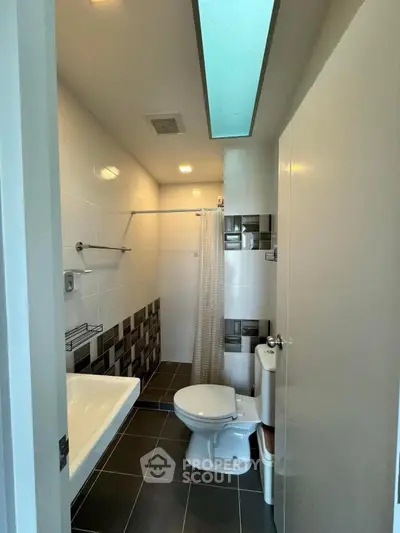 Modern bathroom with sleek design, featuring a bathtub and stylish tile accents.