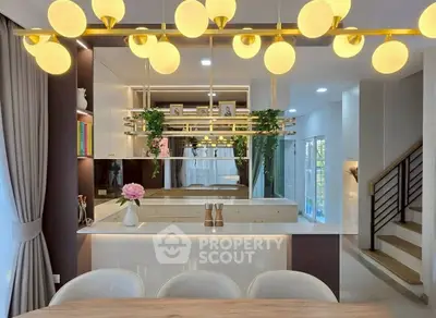 Modern kitchen with elegant lighting and open layout, featuring sleek countertops and stylish decor.