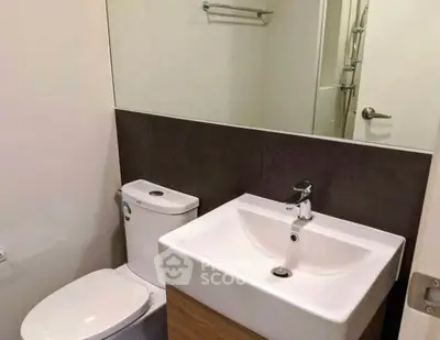 Modern bathroom with sleek fixtures and large mirror in a contemporary apartment.