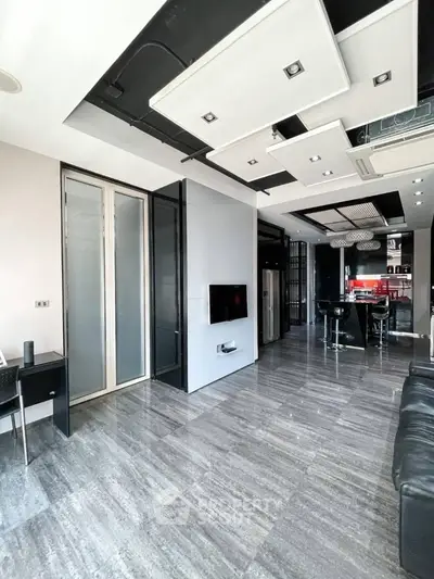 Modern open-plan living room with sleek design and stylish kitchen area