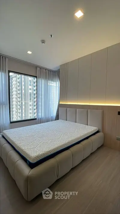 Modern bedroom with large window and stylish bed in high-rise apartment