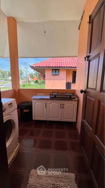 Charming outdoor kitchen with gas stove and washing machine, perfect for versatile living.