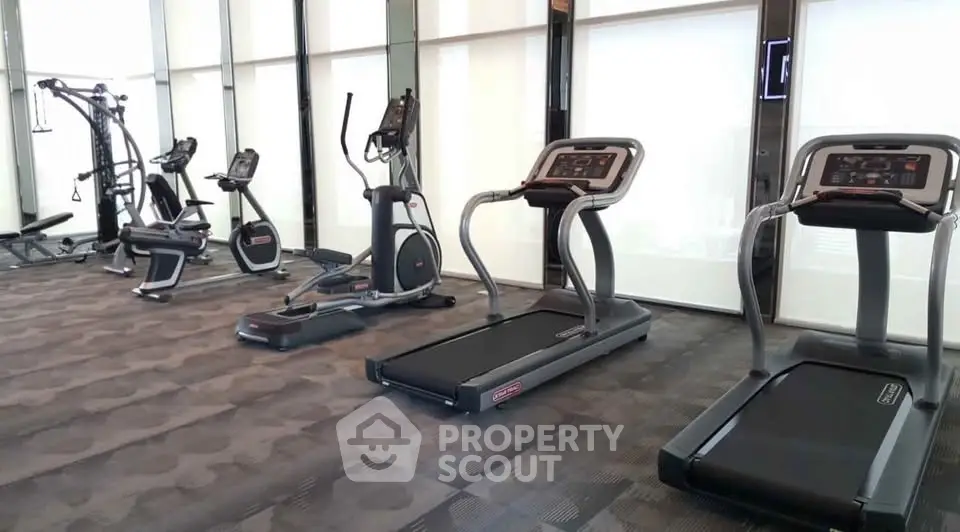 Modern gym with state-of-the-art fitness equipment in luxury apartment building.