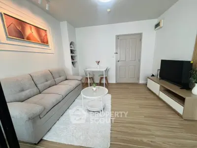 Modern living room with cozy sofa, stylish decor, and sleek TV setup in a bright apartment.