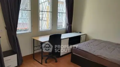 Cozy bedroom with study desk and large windows for natural light