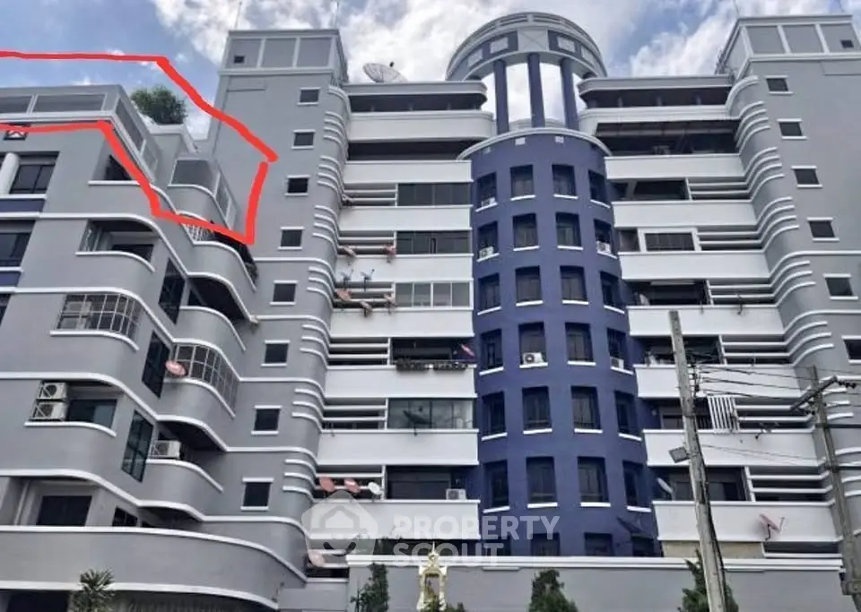 Modern multi-story building with unique architectural design and spacious balconies.