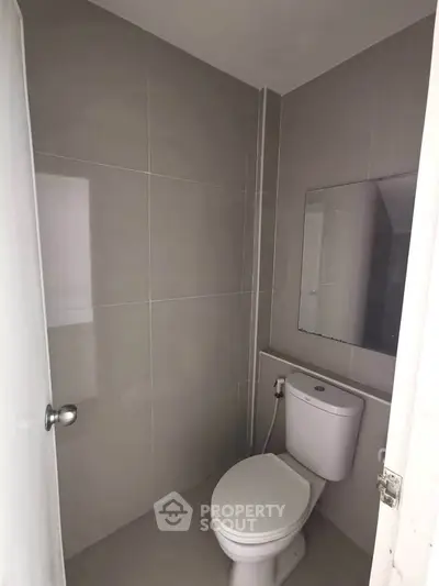 Modern minimalist bathroom with sleek gray tiles and compact design.