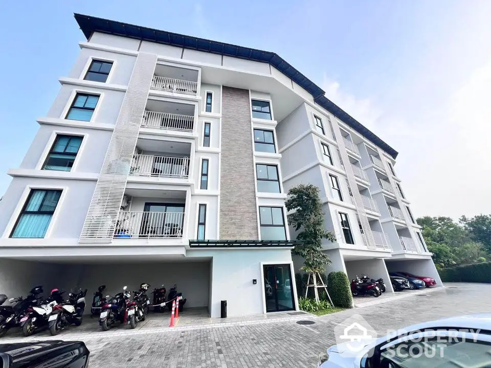 Modern apartment building with spacious balconies and parking area