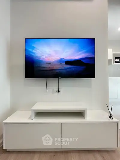 Modern living room with wall-mounted TV and sleek white furniture