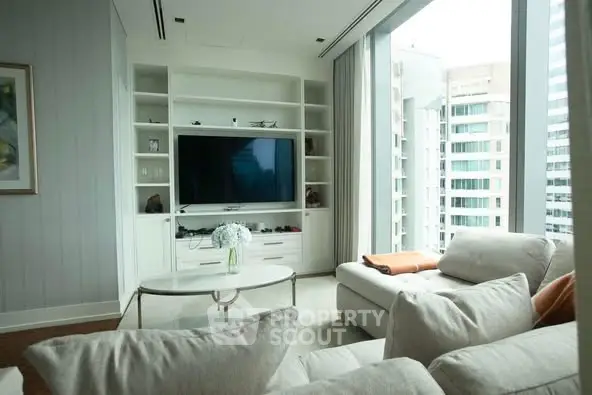 Luxurious living room with modern decor and large windows offering city views.
