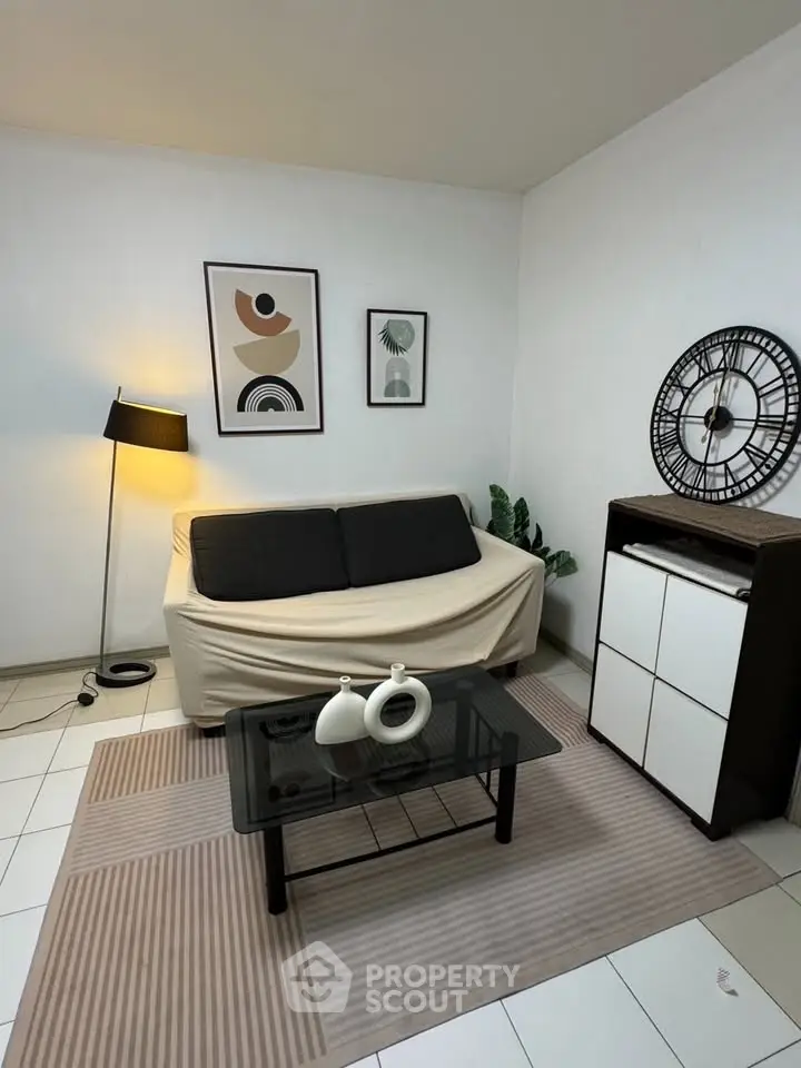 Cozy living room with modern decor, featuring a stylish sofa, chic lamp, and elegant wall art.