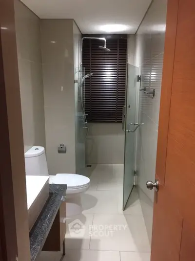 Modern bathroom with glass shower and sleek fixtures in a contemporary apartment.
