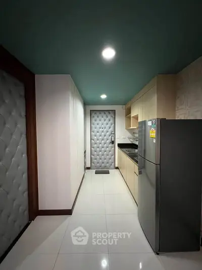Modern kitchen with sleek appliances and stylish cabinetry in a contemporary apartment.