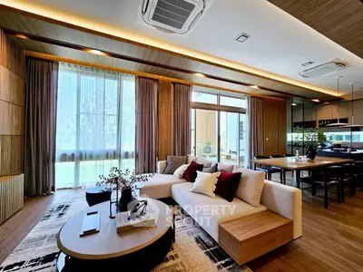 Luxurious modern living room with elegant decor and open layout, featuring large windows and stylish furniture.