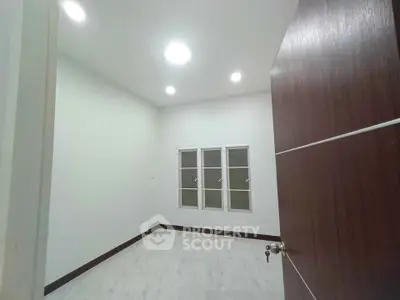 Spacious empty room with modern lighting and large windows, perfect for customization.