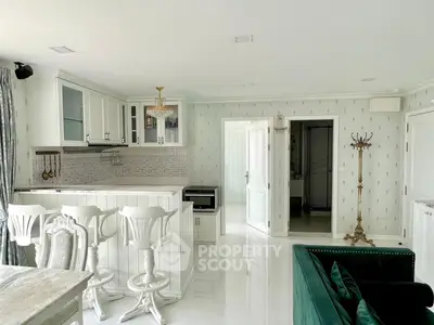 Elegant open-layout kitchen and living area with white cabinetry and stylish decor
