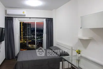 Modern bedroom with city view and balcony access, featuring sleek furnishings and ambient lighting.