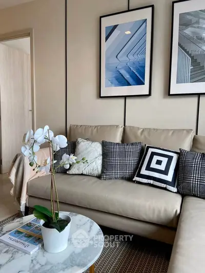 Stylish living room with modern decor, beige sofa, geometric cushions, and elegant wall art.