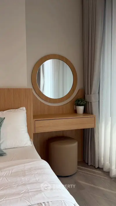 Cozy bedroom with wooden vanity and round mirror, elegant curtains, and soft lighting.