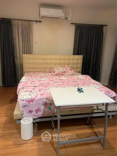 Cozy bedroom with stylish decor and air conditioning, featuring a comfortable bed and elegant curtains.