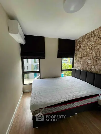 Modern bedroom with large windows and stylish decor in a contemporary apartment.