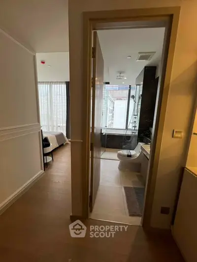 Modern apartment interior with bedroom and bathroom, featuring sleek design and natural light.