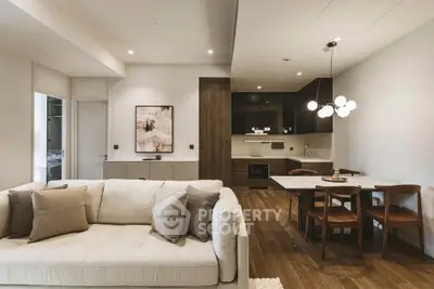 Modern open-plan living room and kitchen with elegant decor and wooden flooring.