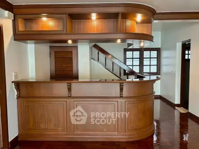Elegant wooden bar in a stylish living room with polished floors and ambient lighting.