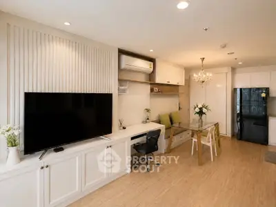 Modern living room with elegant decor, featuring a large TV, dining area, and stylish lighting.