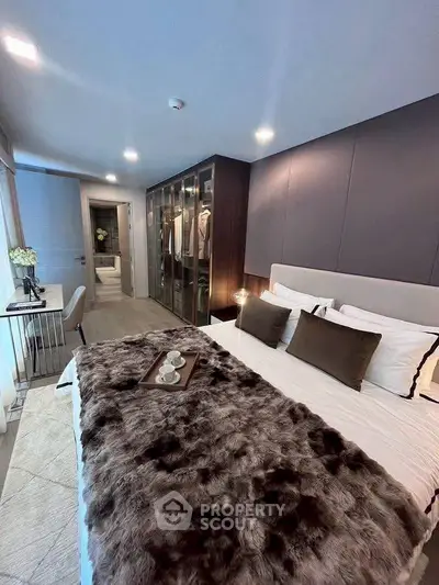 Luxurious bedroom with plush bedding and walk-in closet in modern apartment