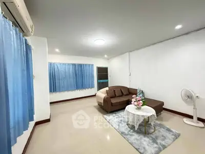 Spacious living room with cozy sofa and elegant decor, perfect for relaxation and entertaining.