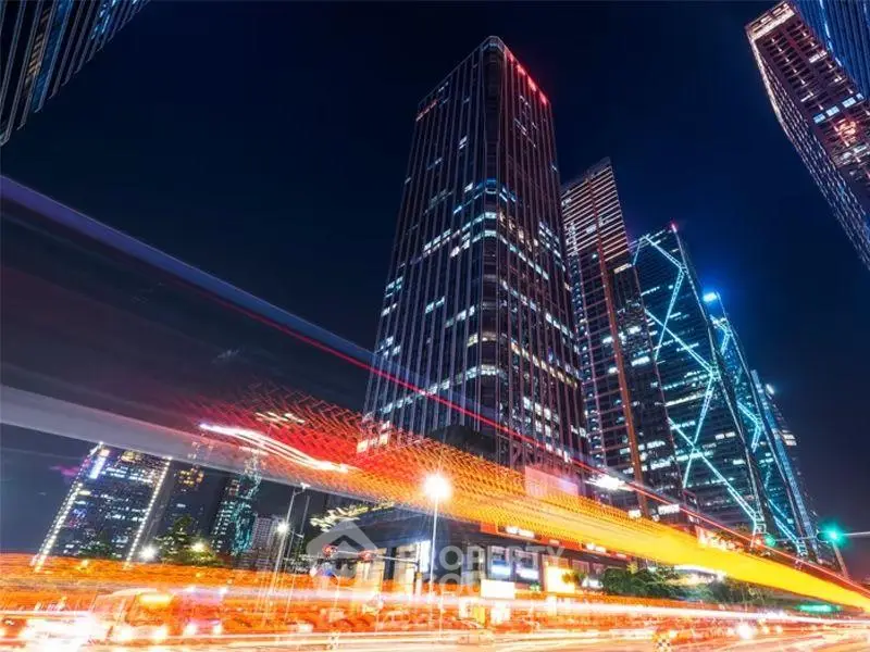 Stunning night view of modern skyscrapers with vibrant city lights and dynamic traffic trails.