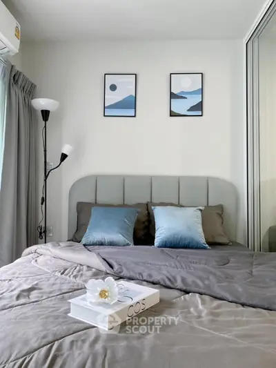 Cozy bedroom with modern decor and stylish artwork, featuring plush bedding and elegant lighting.