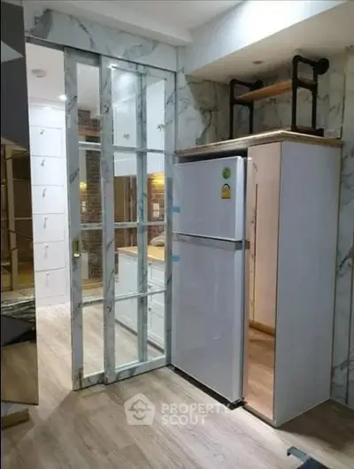 Modern kitchen with sleek marble sliding doors and a spacious fridge, perfect for contemporary living.