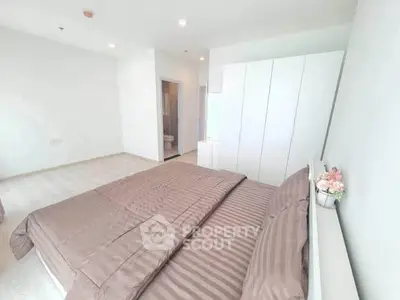 Spacious modern bedroom with elegant decor and ample natural light